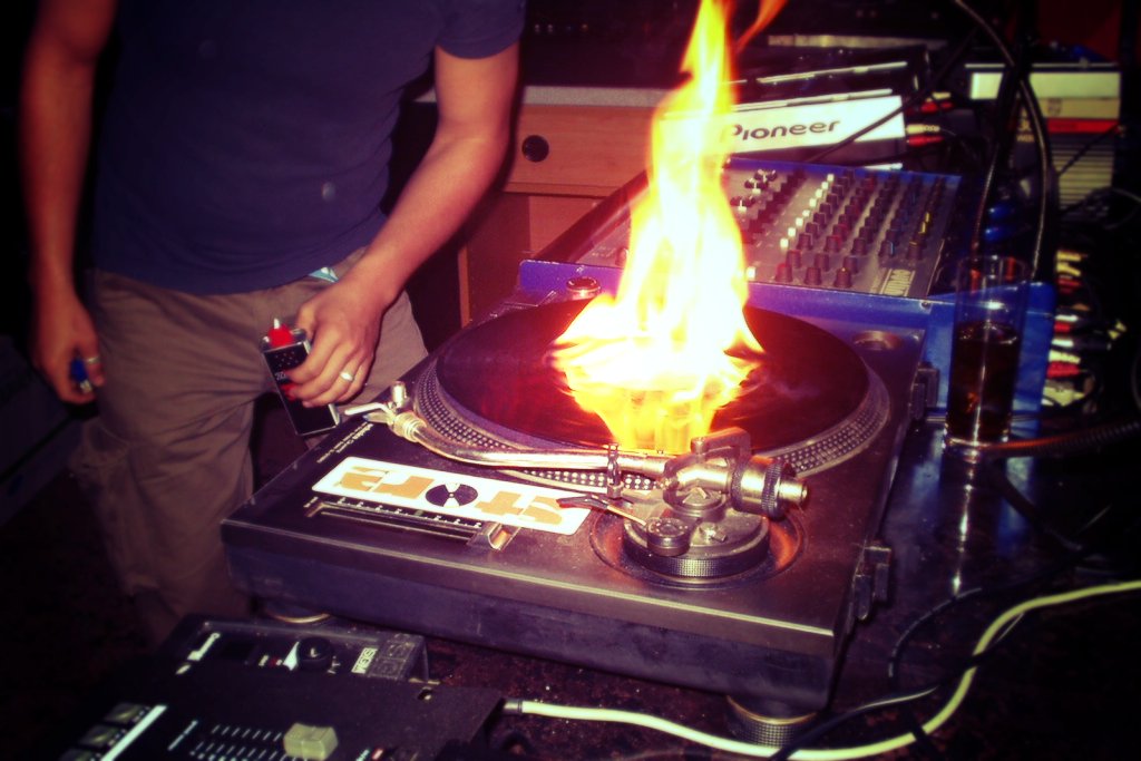 Feuerzeugbenzin brennt auf einer Schallplatte in einer Disco